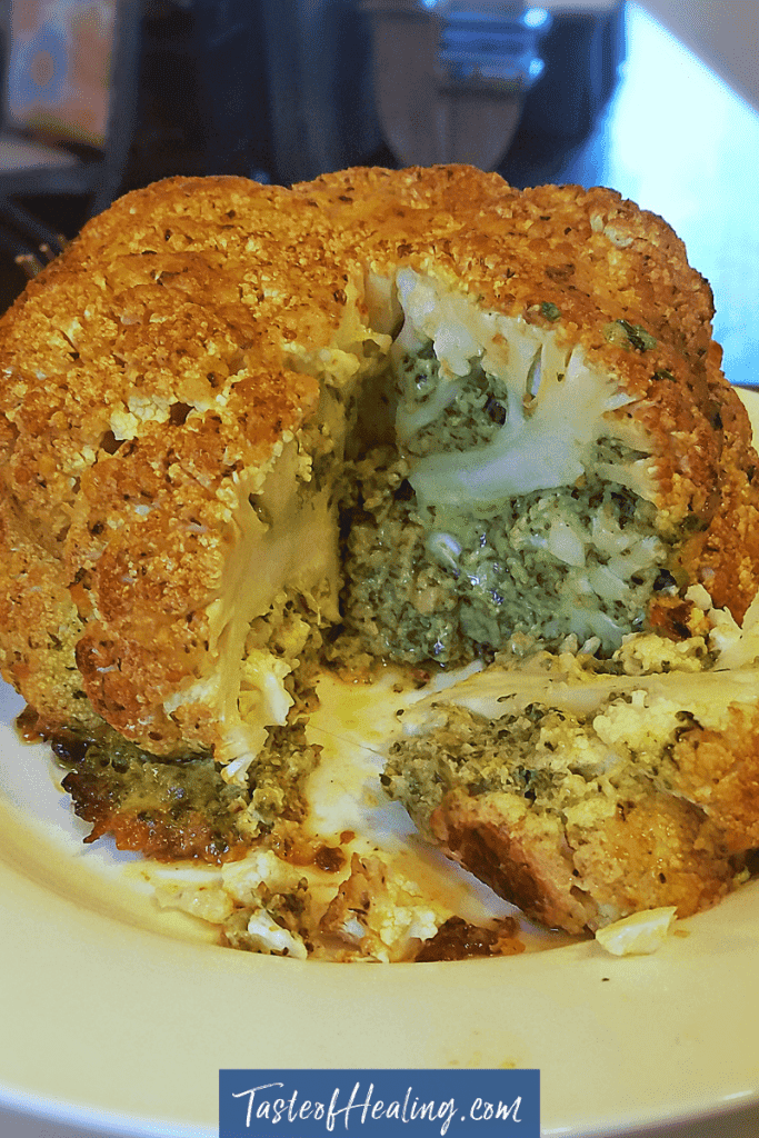 A plate of The Best Whole Roasted Cauliflower with Greens Butter Stuffing